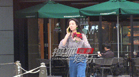 贝股通 齐溪手拿一束鲜花边走路边打电话 风吹起头发又随性又美